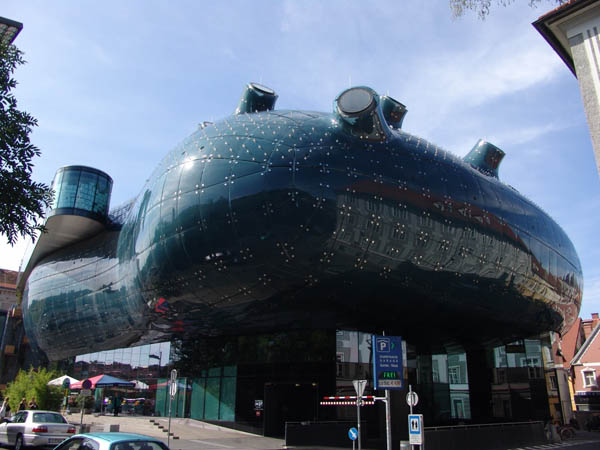 Kunsthaus στο Graz των Peter Cook και Colin Fournier. Το ημιδιαφανές, μπλε, ακρυλικό γυαλί του εξωτερικού κελύφους εντάσσεται στην ιστορικότητα του κέντρου της πόλης, καθώς το αντανακλά με παραμόρφωση στις καμπυλόμορφες, σχεδόν υγρές επιφάνειες του Kunsthaus στο Graz των Peter Cook και Colin Fournier. Το ημιδιαφανές, μπλε, ακρυλικό γυαλί του εξωτερικού κελύφους εντάσσεται στην ιστορικότητα του κέντρου της πόλης, καθώς το αντανακλά με παραμόρφωση στις καμπυλόμορφες, σχεδόν υγρές επιφάνειες του